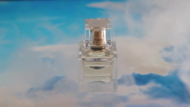 没有人把香水瓶的静谧生活的特写放在抽象的背景图片上 描绘明亮的蓝天 喷出浓烟以获得更好的广告形象 — 图库视频影像