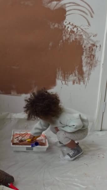 새로운 아파트에서 보육원으로 개조하는 페인트 롤러를 사용하여 Biracial 소녀의 동영상 — 비디오