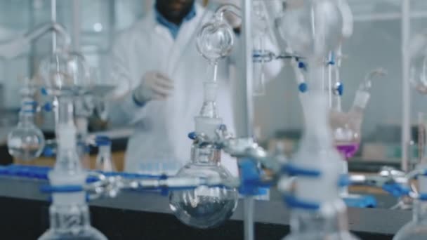 Közepes Felvétel Különböző Kémiai Laborfelszerelésekről Retortákról Flaskákról Lelátókon Afro Amerikai — Stock videók