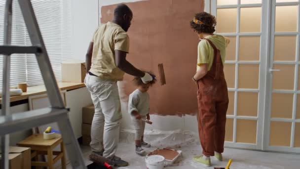 不同家庭成员在为未出生婴儿翻修保育室的同时 用褐色粉刷墙壁的镜头再现 — 图库视频影像