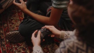 Evde retro oyun konsolları ve 90 'larda nostaljik çocukluk kullanan kimliği belirsiz iki çocuğun TV' de oynadığı yüksek açı görüntüleri.