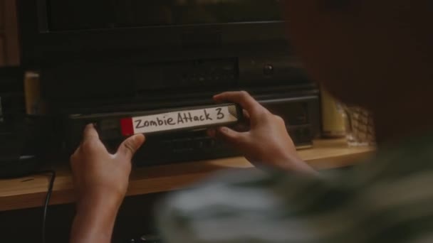 Над Плечовими Кадрами Невизначеного Хлопчика Який Поклав Касету Фільмом Zombie — стокове відео