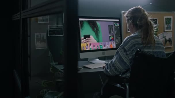 컴퓨터 모니터 책상에 휠체어에 장애가있는 그래픽 디자이너의 다채로운 이미지 어두운 — 비디오
