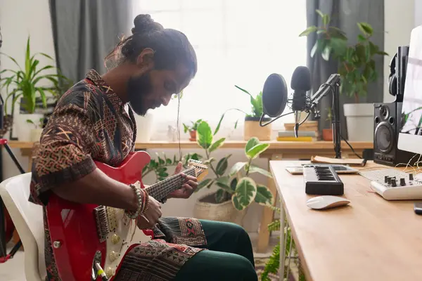 Genç yetenekli bir adamın iş yerinde oturup elektro gitar çalması ve yeni müzik bestelemesi.