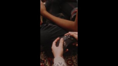 Evlerinde retro oyun konsolları, 90 'larda nostaljik çocukluk kullanan kimliği belirsiz iki çocuğun TV' de oynadığı dikey yüksek açı görüntüleri.