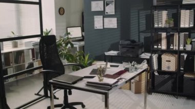 Günümüz boş avukatlık bürosunun açık dizüstü bilgisayarı, döküman yığını ve masanın üzerinde Themis figürü, raflarda bir sürü klasör ve duvarda sertifikalar.