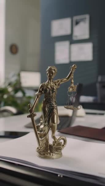 法律事務所のオフィステーブルに女性正義の青銅像の垂直映像 法律と秩序のバランスのシンボル コピースペース — ストック動画