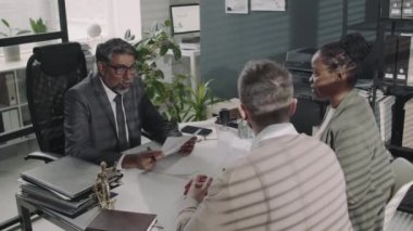 Çift ırklı avukatın çeşitli iş ortaklarına danışarak modern hukuk firmasında ortak girişim anlaşmasına girişini gösteren bir video kaydı.