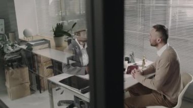 Yasal yardım bürosundaki istişareden sonra Afrikalı Amerikalı kadın avukatla tokalaşan memnun erkek beyaz müşterinin yan çekim görüntüleri.