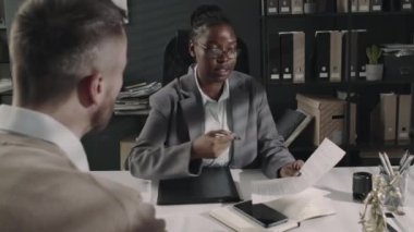 Kimliği belirlenemeyen erkek müşterinin arka görüntüleri. Kadın hukukçunun danışmanlık bürosundaki hukuki madde ve nüanslarını dinlemesi.