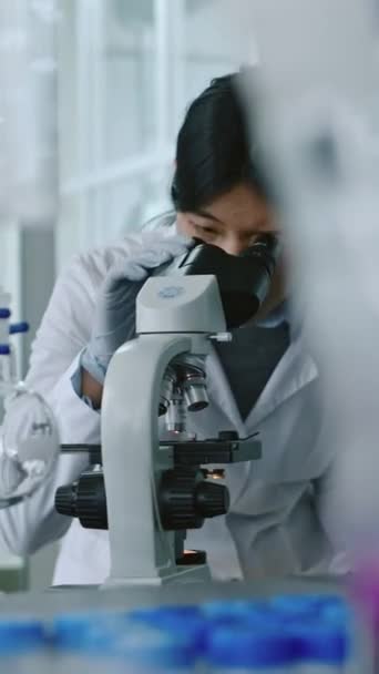 Közepes Függőleges Fiatal Kínai Női Kutató Laborköpenyben Kesztyű Lehajolva Mikroszkóp — Stock videók