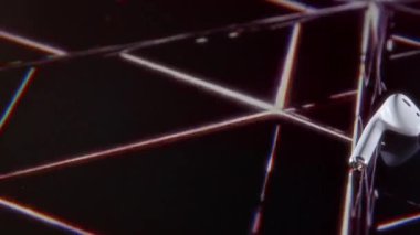 Stüdyoda soyut hareketli neon yüzey üzerinde duran beyaz kulaklıklar serisinin reklamını kimse yakından çekmez.