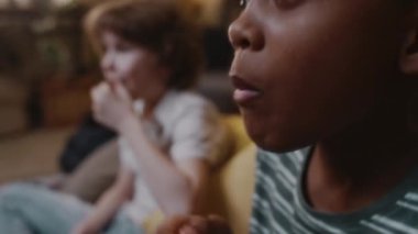 Afrikalı Amerikalı çocuğun beyaz bir arkadaşla muhteşem bir film izlediği, TV ekranına bakıp evde patlamış mısır yediği, 90 'ların nostaljik atmosferini izlediği yakın çekim.