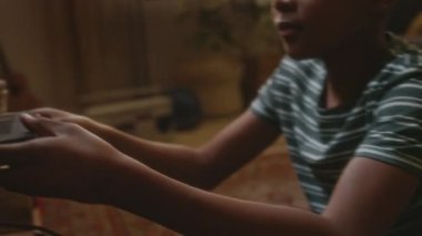 Afro-Amerikan çocuğun okul çantasından kaseti alıp video kaydediciye koyduğu ve evde tek başına korku filmi izlerken eski televizyonu açtığı el kamerası görüntüleri.