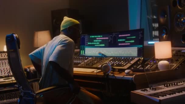 Medium Bak African American Inspelningsingenjör Studio Sitter Ner Framför Arbetsstationen — Stockvideo