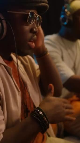 모자에 아프리카계 래퍼의 선글라스 스튜디오에 헤드폰 흔들어 책상에 조정을 만드는 — 비디오