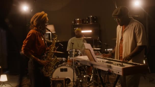 아프리카계 미국인 뮤지션의 모자와 선글라스 키보드를 색소폰을 드럼에 스튜디오에서 리허설 — 비디오