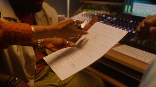 非洲裔美国女歌手手牵手站在桌子旁边 拿着写字板和歌词 与制作人激烈辩论 同时在录音室制作新的音乐专辑 — 图库视频影像