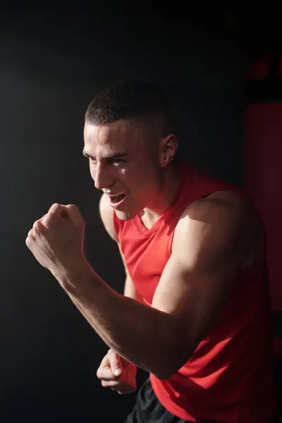 Młody Podekscytowany Mężczyzna Czerwonej Odzieży Sportowej Trzyma Zaciśniętą Pięść Przed Zdjęcie Stockowe