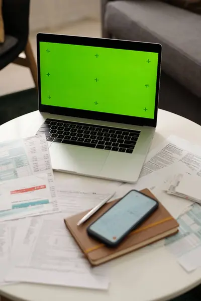 未払いの請求書と金融紙 メモ帳 スマートフォンでテーブルの上に立っているスクリーンのクロマキー付きのラップトップのハイアングル ロイヤリティフリーのストック画像