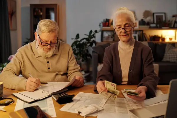 Hombre Anciano Con Cuentas Financieras Mano Haciendo Notas Página Cuaderno Imágenes De Stock Sin Royalties Gratis