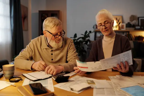 Pasangan Senior Melihat Tagihan Pembayaran Tangan Wanita Tua Sambil Memeriksa Stok Gambar