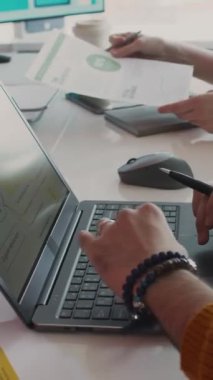 Üç aylık toplantıda beyin fırtınası yapan çeşitli şirket çalışanlarının dikey çekimleri, grafik ve diyagramlarla sunum slaytı üzerinde çalışan erkek pazarlama uzmanı.