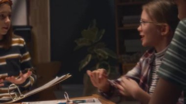 Hikaye anlatıcısının oyunu komik bir şekilde açıklarken ve kız evde oyun oynarken gülerken, çocuklar oyun sürecinden zevk alırken.