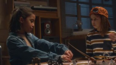 İspanyol kız oyuncu ve beyaz erkek hikaye anlatıcısının akşam evde masa oyunu oynarken yan görüntüsü.