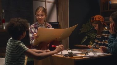 Beyaz kızın oyun yöneticisi olarak el kamerasında büyük bir klasör ve masa oyununun yönetim süreciyle evde çok ırklı arkadaşlarıyla oynarken görülüyor.