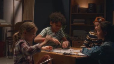 Küçük kızın masa oyunu için çizilmiş konum haritasına ayrıntılar eklediği arka plan. Bu arada çok ırklı arkadaşlar onu akşam evde izliyorlar.