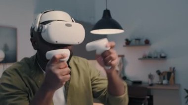 Arttırılmış gerçeklik gözlüklü Afro-Amerikan bir adamın metaevrende sanal rakibine yumruk attığı göğüs üstü fotoğraf.