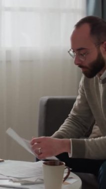 Genç Orta Doğulu bir adamın iç harcamaları yönettiği, zarfı açtığı, yeni bir fatura çıkardığı, okuduğu, yumruğunu sıktığı ve öfkeyle küfrettiği orta boy dikey bir fotoğraf.