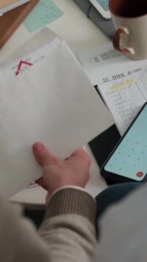 Kimliği belirsiz genç bir çiftin mali meselelerle ilgilenirken orta boy dikey çekimi. Kocasının gecikmiş faturasını çıkarması, el kol hareketi yapması, yüksek benzin fiyatına işaret etmesi, karısının omzunu okşaması.