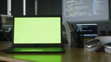 Programlama sınıfındaki boş yeşil ekranlı dizüstü bilgisayarı, düşük tuşlu bulanık arka planlı bilgisayar kodlu ekranları olmayan orta ölçekli insanlar. Şablon kadar uygun, alanı kopyala