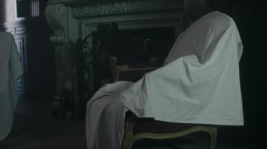 Terkedilmiş lüks malikanenin karanlık oturma odasındaki şöminenin yanındaki çarşafla kaplı koltuktan vurulan insanlar yok.