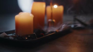 Mistik tören için yanan mumların yanına siyah porselen tepsiye konmuş yanan palo santo çubuğundan çıkan dumandan hiç kimse vurulmaz.