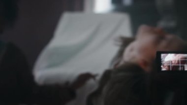 Kız arkadaşının vücudunu ele geçiren iblisin el kamerasıyla çekilmiş görüntüsü. Delikanlı kıvranıyor, arkadaşları panikliyor ve terk edilmiş evde ona yardım etmeye çalışıyor.