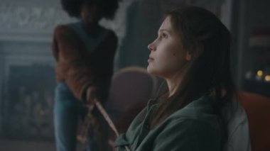 Sandalyede kıvranan, dua eden ve panikleyen arkadaşlarının eski evlerinde ayin yaptıktan sonra onu iple bağladıkları solgun iblis kız pozu.