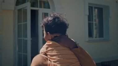 Genç Afrikalı Amerikalı karı ve babanın büyükbabalarını ziyaret ederken, bir şişe şarap ve turta getirirken, sarılırken, neşeyle sohbet ederken orta boy yakın plan çekimleri.