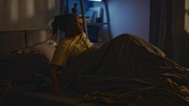 Afro-Amerikalı bir kadının gece kâbusundan uyandığı ve yatakta uyumakta güçlük çektiği bir sahne.