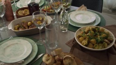 Pazar öğle yemeği için ziyafet masasına serilmiş iştah açıcı yiyecekler yok. Bir kase fırında patates, kızarmış tavuk, dilimlenmiş ekmek, mantar turşusu, salata, turta, ev yapımı şarap.