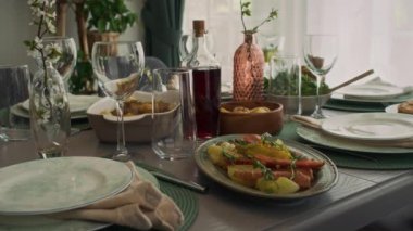 Orta ölçekli hiç kimse fırında patates, havuç, salata, kızarmış tavuk, ev yapımı şarap şişesi ile pazar günü yemek odasında aile kahvaltısı için hazırlanan sofraya oturmayacak.