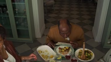 Afrika kökenli Amerikalı bir kızın ailesiyle yemek masasında oturup, babasıyla ve büyükbabasıyla gülerken, ana yemeği yerken ve bayramı birlikte kutlarken çekilmiş en iyi fotoğrafı.