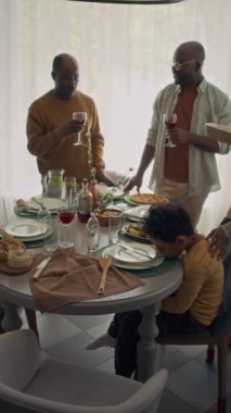 Afrika kökenli Amerikalı ailenin tam dikey yavaşlığı evde şenlikli bir akşam yemeğine otururken, anne ve kız tepsileri sıcak yiyecekle getiriyorlar, bu sırada baba ve büyükbaba cam kenarında ev yapımı şarabı tadıyorlar.