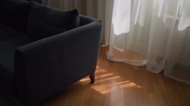 Aile evinde pencerenin yanında duran mavi kanepeden vurulan ve güneşli yaz gününde hafif sallanan şeffaf beyaz pencere perdesi yok.