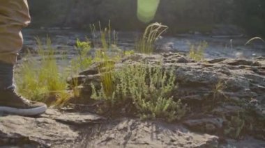 Nehrin yukarısındaki tepede durup yaz yürüyüşü sırasında çevreye bakan Kafkas kadın yürüyüşçünün düşük açılı mercekli görüntüsü.