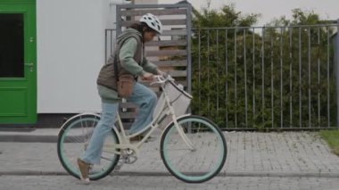 Çevredeki gazete dağıtımında çalışan, bisikletli Afrikalı Amerikalı genç kızın yavaş çekimleri.