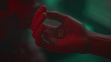 Kimliği belirsiz birinin avuç içini simgeli iki Mdma hapıyla açması, bir diğerinin bir hap alması, gece kulübünde kırmızı ve yeşil neon ışıklı ecstasy alması.