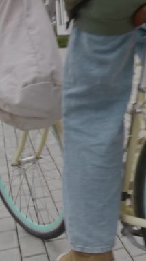 Boş zamanlarında bisiklet kaskı takan genç bir kızın kaldırımda bisiklet sürmesinin dikey yavaşlığı.
